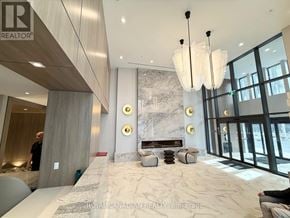 Hamilton (Corktown) condo for rent - A spacious lobby with a marble floor and a large chandelier.