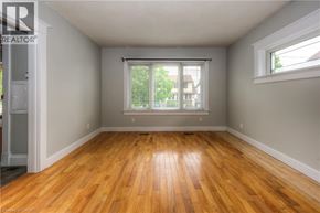 Kitchener apartment for rent - A room with wooden floors and a window with blinds.