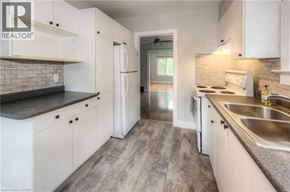Kitchener apartment for rent - A kitchen with white cabinets and a brick backsplash.