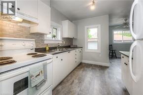 Kitchener apartment for rent - A kitchen with white cabinets and a white stove top oven.