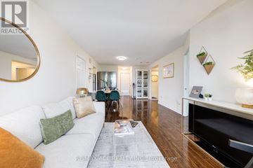 Toronto (Newtonbrook East) condo for rent - A living room with a white couch and a coffee table in front of a fireplace.