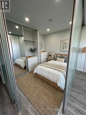 Toronto (Annex) multi-family for rent - A bedroom with a large bed and a mirror on the wall.
