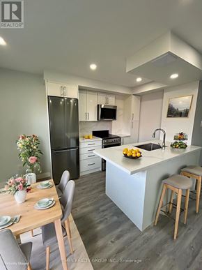 Toronto (Annex) multi-family for rent - A modern kitchen with a dining table set for two.