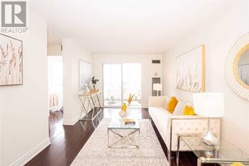Mississauga (Cooksville) condo for rent - A living room with a white couch and a glass coffee table.