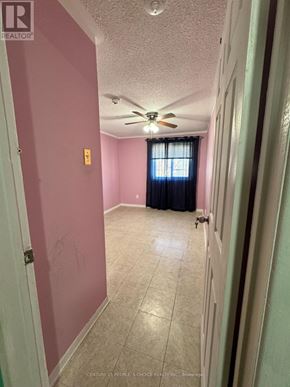 Mississauga (Malton) apartment for rent - A room with a ceiling fan and a door leading to another room.