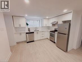 Kitchener apartment for rent - A kitchen with white cabinets and a refrigerator.