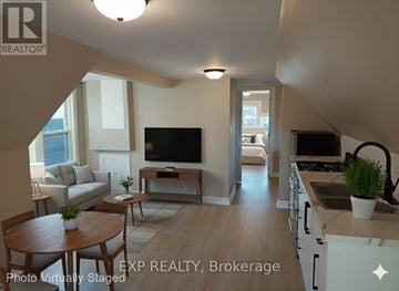 Hamilton (Gibson) apartment for rent - A living room with a television and a kitchen area in the background.
