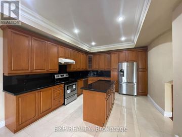 Toronto (Centennial Scarborough) apartment for rent - A kitchen with wooden cabinets and black countertops.