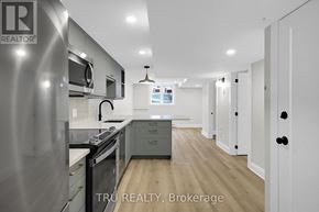 Ottawa apartment for rent - A modern kitchen with stainless steel appliances and wooden flooring.