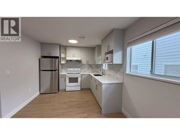 Burnaby apartment for rent - A kitchen with white appliances and wooden floors.