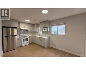Burnaby apartment for rent - A well-lit kitchen with a refrigerator, oven, and microwave.