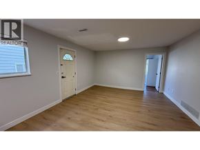 Burnaby apartment for rent - A room with wooden flooring and white walls, with a door on the left and a window on the right.