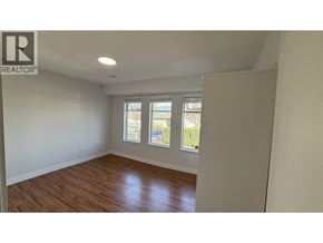 Burnaby apartment for rent - A room with a window showing a view of a street and houses.