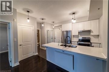 Burlington condo for rent - A kitchen with white cabinets and a blue island.