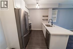 Burlington condo for rent - A modern kitchen with a white countertop and stainless steel appliances.