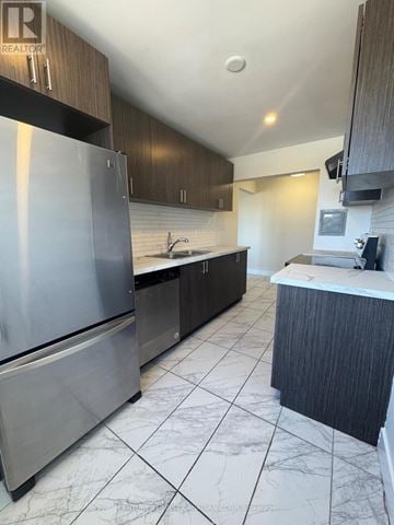 London South (South F) condo for rent - A modern kitchen with a stainless steel refrigerator and dark wood cabinets.