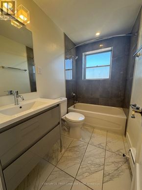London South (South F) condo for rent - A bathroom with a toilet, sink, and bathtub.