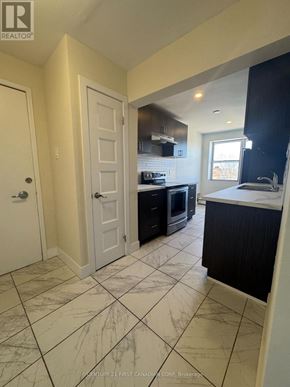 London South (South F) condo for rent - A kitchen with a marble floor and a black counter.