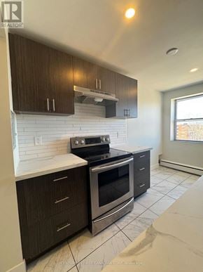 London South (South F) condo for rent - A kitchen with dark wood cabinets and a white subway tile backsplash.