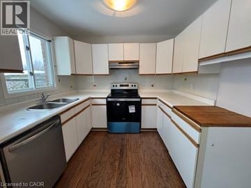 Waterloo apartment for rent - A kitchen with white cabinets and a wooden counter top.