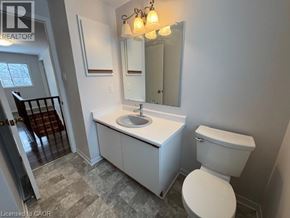 Waterloo apartment for rent - A bathroom with a toilet, sink, and mirror.