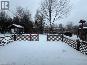 Waterloo apartment for rent - A snow-covered landscape with a wooden fence and a small building in the distance.