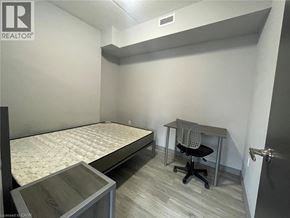 Waterloo condo for rent - A bedroom with a bed, desk, and chair.