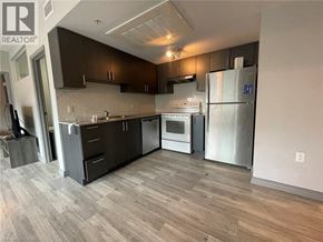 Waterloo condo for rent - A modern kitchen with dark wood cabinets and stainless steel appliances.