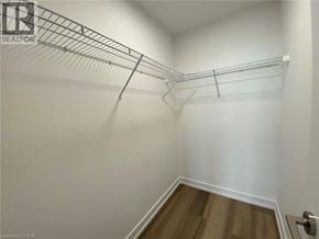 Kitchener condo for rent - A white wall with a metal rack and a wooden floor.
