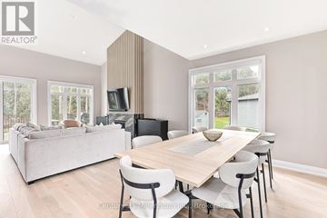 Blue Mountains apartment for rent - A modern living room with a large grey sofa and a wooden dining table with chairs.