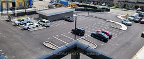 Hamilton (Waterdown) condo for rent - A parking lot with cars and a building in the background.