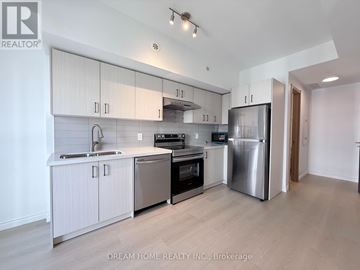 Toronto (Tam O'shanter-Sullivan) townhouse for rent - A modern kitchen with white cabinets and stainless steel appliances.