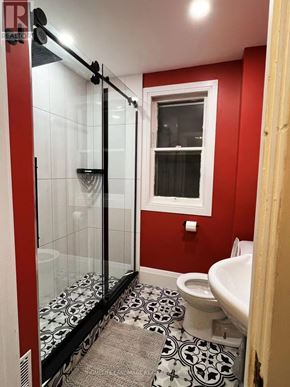 Niagara Falls (Hospital) apartment for rent - A bathroom with red walls and a black and white floor.