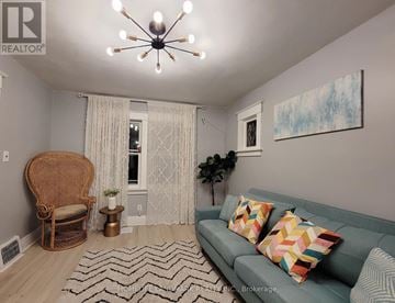 Niagara Falls (Hospital) apartment for rent - A living room with a couch, chair, and a painting on the wall.