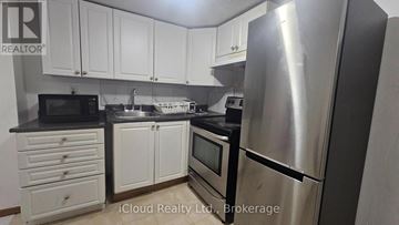 Toronto (Wexford-Maryvale) apartment for rent - A kitchen with white cabinets and a stainless steel refrigerator.