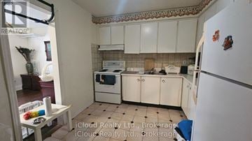 Toronto (Wexford-Maryvale) apartment for rent - A kitchen with white cabinets and a white fridge.