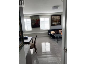Vancouver apartment for rent - A living room with a couch, chair, and painting on the wall.