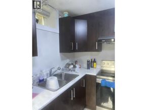 Vancouver apartment for rent - A kitchen with a sink, stove, and cabinets.