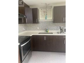 Vancouver apartment for rent - A kitchen with brown cabinets and a black oven.