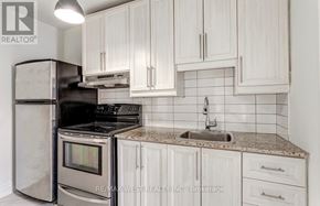 Toronto (Junction Area) apartment for rent - A kitchen with white cabinets and a granite countertop.