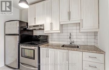 Toronto (Junction Area) apartment for rent - A kitchen with white cabinets and a granite countertop.