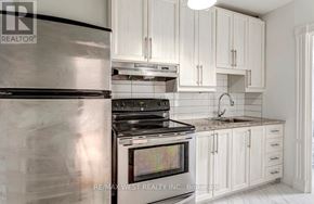 Toronto (Junction Area) apartment for rent - A modern kitchen with white cabinets and a stainless steel refrigerator.