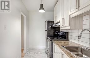 Toronto (Junction Area) apartment for rent - A kitchen with a black stove top oven and white cabinets.