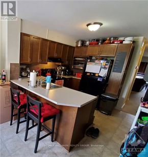 Ottawa townhouse for rent - A kitchen with a white counter top and wooden cabinets.