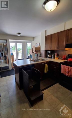 Ottawa townhouse for rent - A kitchen with a sink, stove, and cabinets.