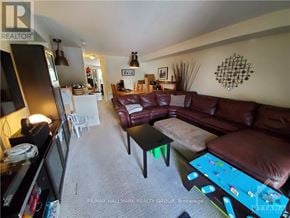 Ottawa townhouse for rent - A living room with a brown couch and a white chair.