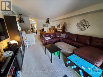Ottawa townhouse for rent - A living room with a brown couch and a white chair.