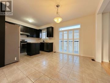 Markham (Wismer) apartment for rent - A kitchen with black cabinets and a silver refrigerator.