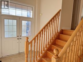 Markham (Wismer) apartment for rent - A staircase with a wooden banister and a white door with a glass window.
