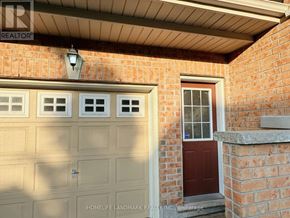 Markham (Wismer) apartment for rent - A red door is on the right side of a white garage door.